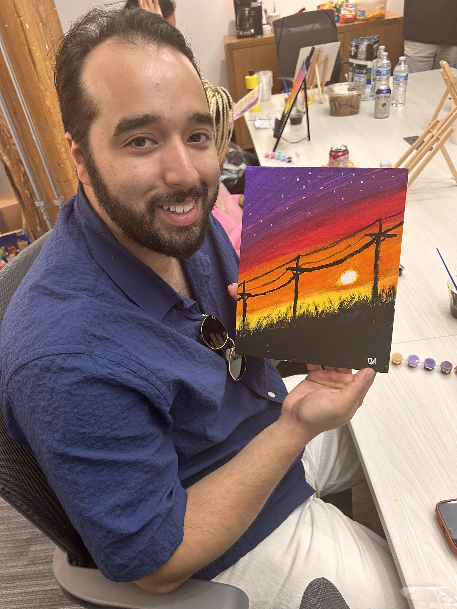 Student showing off his painting after class