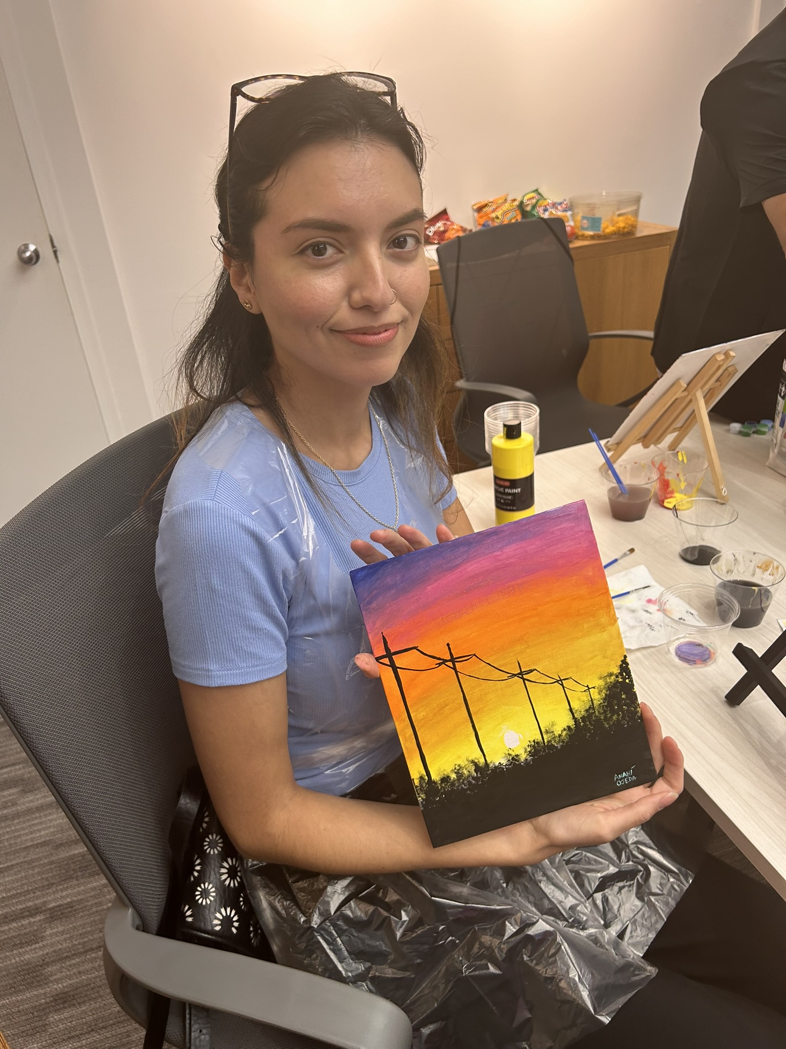 Bella F. showing off her painting after class